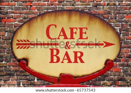 A rusty old retro arrow sign with the text Cafe and Bar