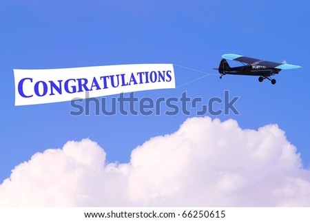 An airplane towing a banner with the word Congratulations in blue, good for male related themes or birth of a baby boy