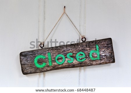 Photo of a rustic wooden shop door sign Closed.