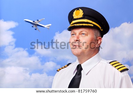 Photo of an airline pilot wearing the four bar Captains epaulettes, shot against a sky background with jumbo jet taking off in the distance.