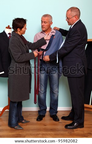 Photo of a man getting advice from his wife during a tailored bespoke suit fitting.