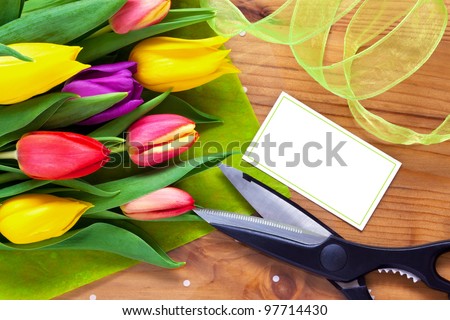 Bouquet of flowers on a table in a florist shop, blank card with copy space to add your own message.