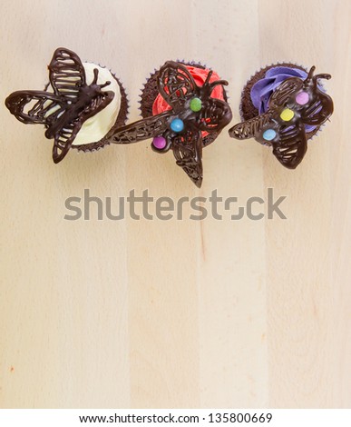 Chocolate butterfly decorated cupcakes on a pastry board