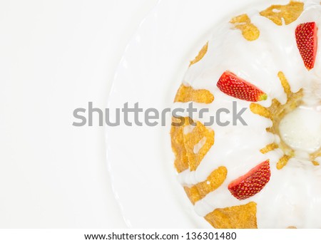 Cheese pound cake coated with sugar glaze and pieces of strawberry