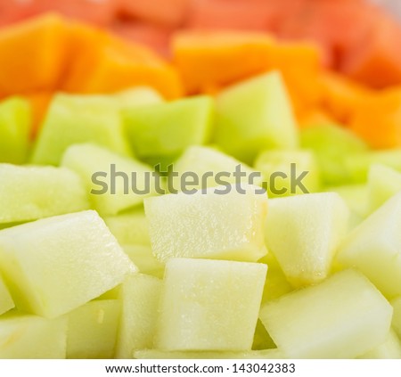 Bite size melons and honeydews over white background