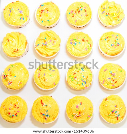 Yellow cupcakes over white background