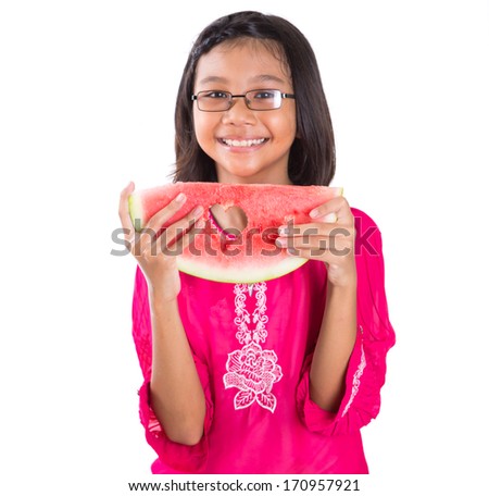 Young asian girl with a heart cut out out shape on a slice of watermelon over white background