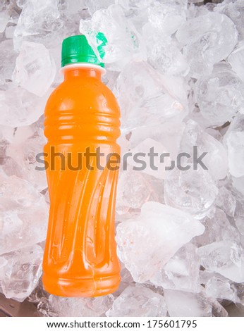 Bottle mango juice cooled with ice cubes