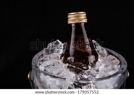 A bottle of drink kept chilled in a crystal made ice bucket