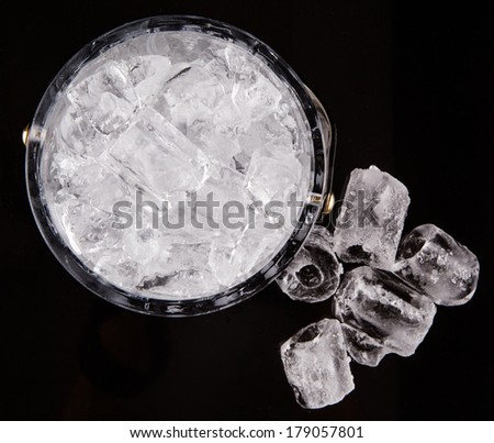 Crystal ice bucket with ice over black background