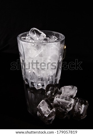 Crystal ice bucket with ice over black background
