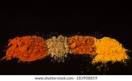 Mixed powdered spices over black background
