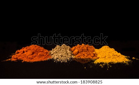 Mixed powdered spices over black background