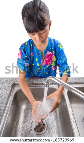 Young girl washing a glass at the kitchen sink