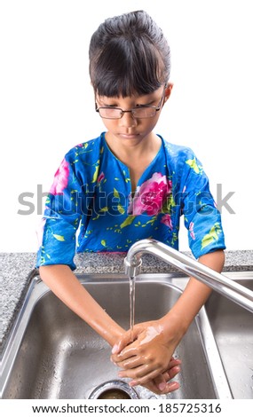 Young Asian Malay girl washing hands at the kitchen sink