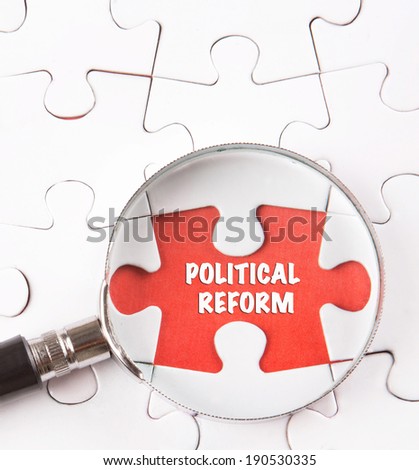 Concept image of missing jigsaw puzzle pieces found by magnifying glass revealing the POLITICAL REFORM words.