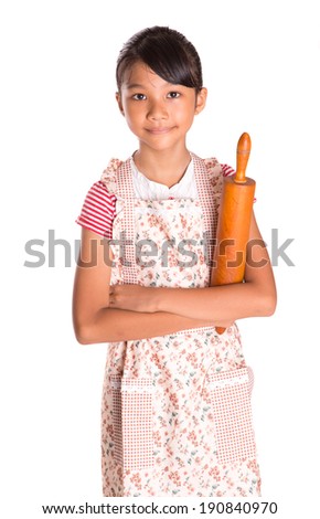 Young Asian Malay girl wearing kitchen apron with a wooden rolling pin over white background