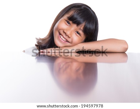 Young Asian Malay girl with her face reflection on a wooden table surface