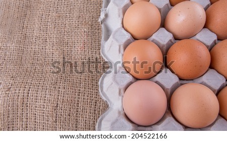 Chicken eggs in egg carton on gunny sack