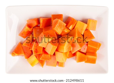 Bite sized papaya fruit on white plate over white background
