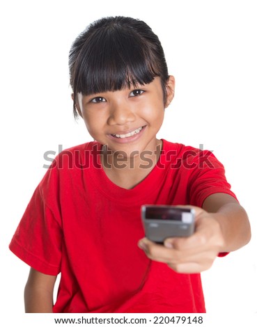 Young Asian girl with television remote control device over white background