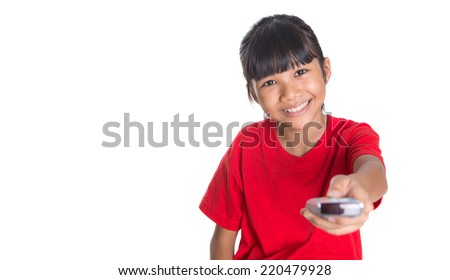 Young Asian girl with television remote control device over white background