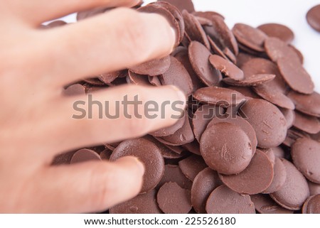 Close up view of hand picking up chocolate button