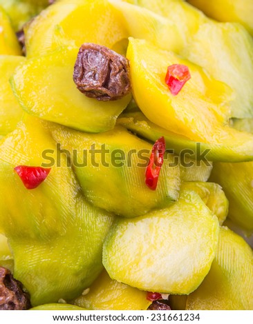 Close up view of pickled young mango with dried tamarind and chili slices