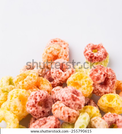 Colorful fruit flavored loops shaped cereal over white background