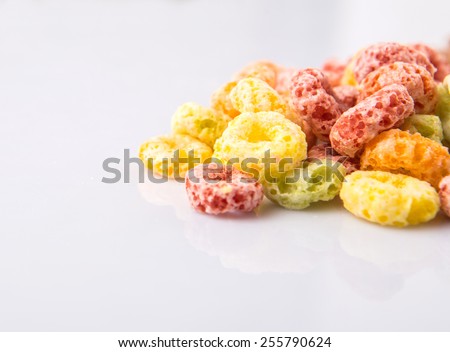 Colorful fruit flavored loops shaped cereal over white background