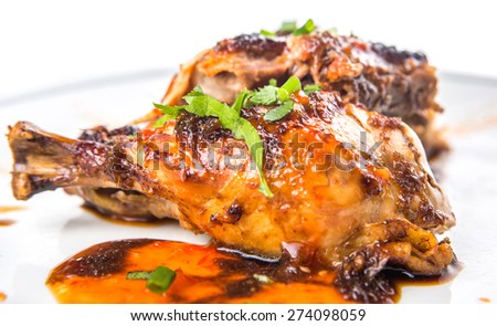 Malaysian dish of roasted chicken pieces coated with soy sauce and chili sauce on white plate