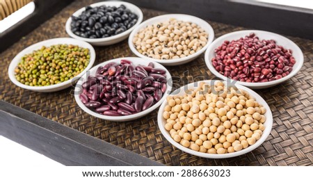 Black eye peas, mung bean, adzuki beans, soy beans, black beans and red kidney beans in white bowl on wicker tray