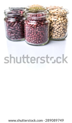 Black eye peas, chickpeas, adzuki beans, mung bean, soy beans, black beans and red kidney beans in mason jars over white background