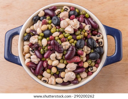 Mix bean of black eye peas, mung bean, adzuki beans, soy beans, black beans and red kidney beans in a blue pot over wooden background