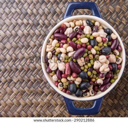 Mix bean of black eye peas, mung bean, adzuki beans, soy beans, black beans and red kidney beans in a blue pot over wicker background