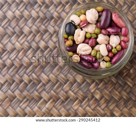 Mix bean of black eye peas, mung bean, adzuki beans, soy beans, black beans and red kidney beans in a mason jar over wicker background