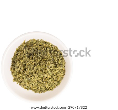 Dried parsley herbs in white bowl over white background
