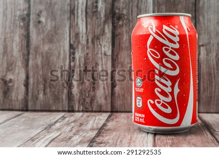 PUTRAJAYA, MALAYSIA - JUNE 28TH, 2015. Coca Cola can on weathered wood. Coca Cola drinks are produced and manufactured by The Coca-Cola Company, an American multinational beverage corporation.