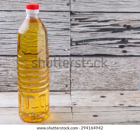 Vegetable cooking oil in a bottle over aged weathered wooden background
