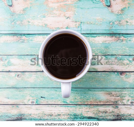 A mug of coffee drink over rustic weathered wooden background
