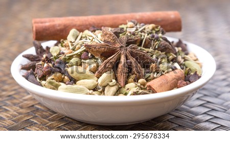 Mix herbs and spices in white bowl over wicker background