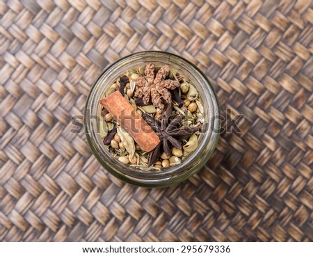 Mix herbs and spices in mason jar over wicker background