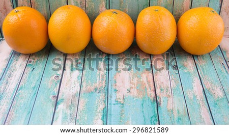 Orange fruits over weathered wooden background