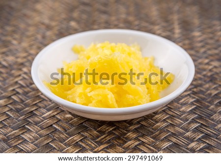 A bowl of Indian ghee in white bowl over wicker background