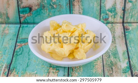 A bowl of margarine in white bowl over wooden background