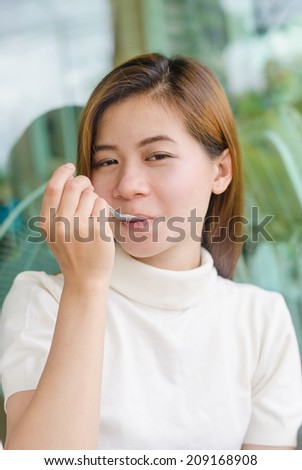 Beautiful asian  woman sitting in cafe eating chocolate cake.