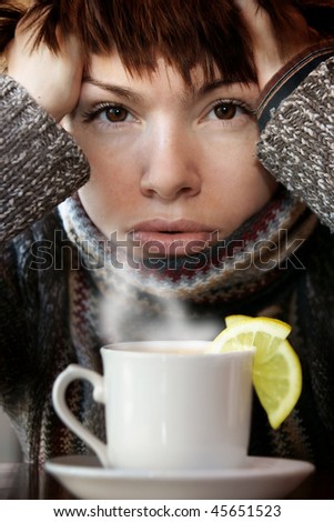 young beautiful woman in knitted scarf,  with the cup of hot tea