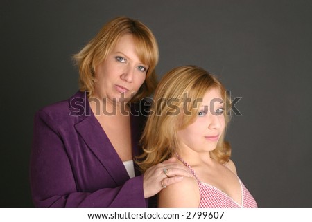 Concerned mother comforts her blond teenage daughter