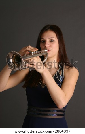 Teenage girl wearing dark prom dress and holding a trumpet