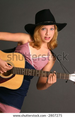 Teenage girl in country western outfit with guitar